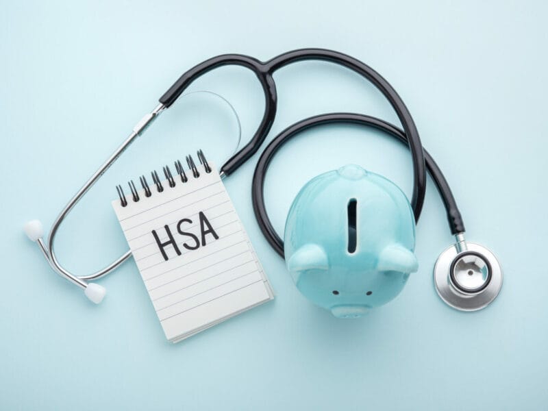 piggy bank, stethescope, and notebook with 'HSA' written on it