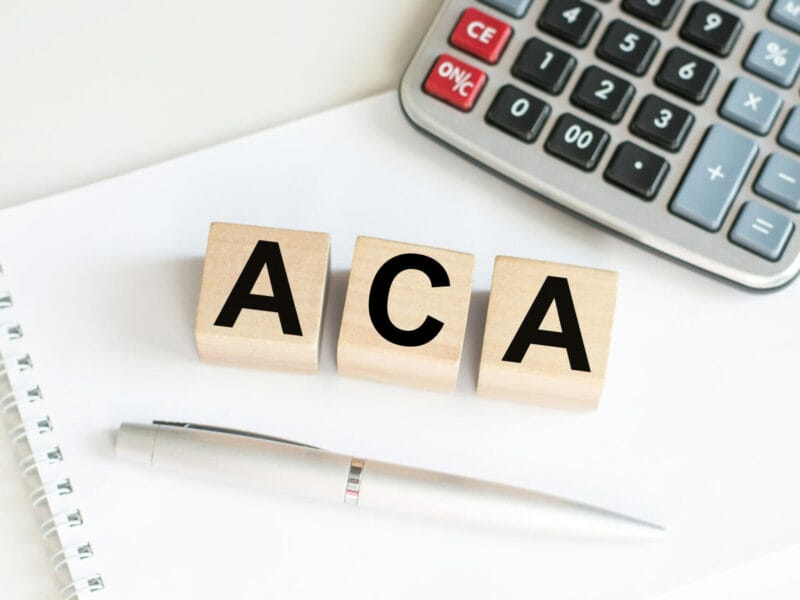 ACA spelled out in blocks sitting on desk