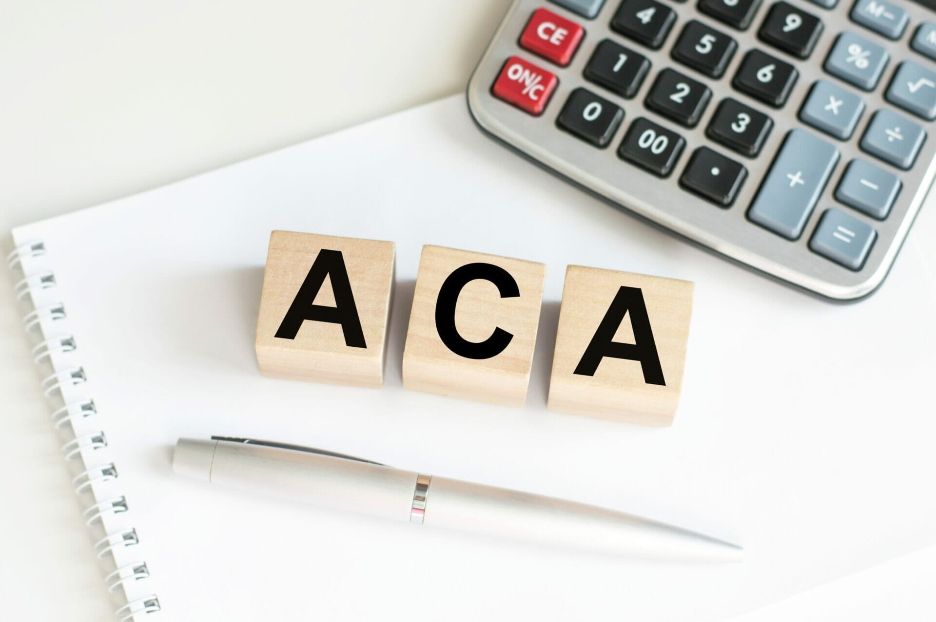 ACA spelled out in blocks sitting on desk