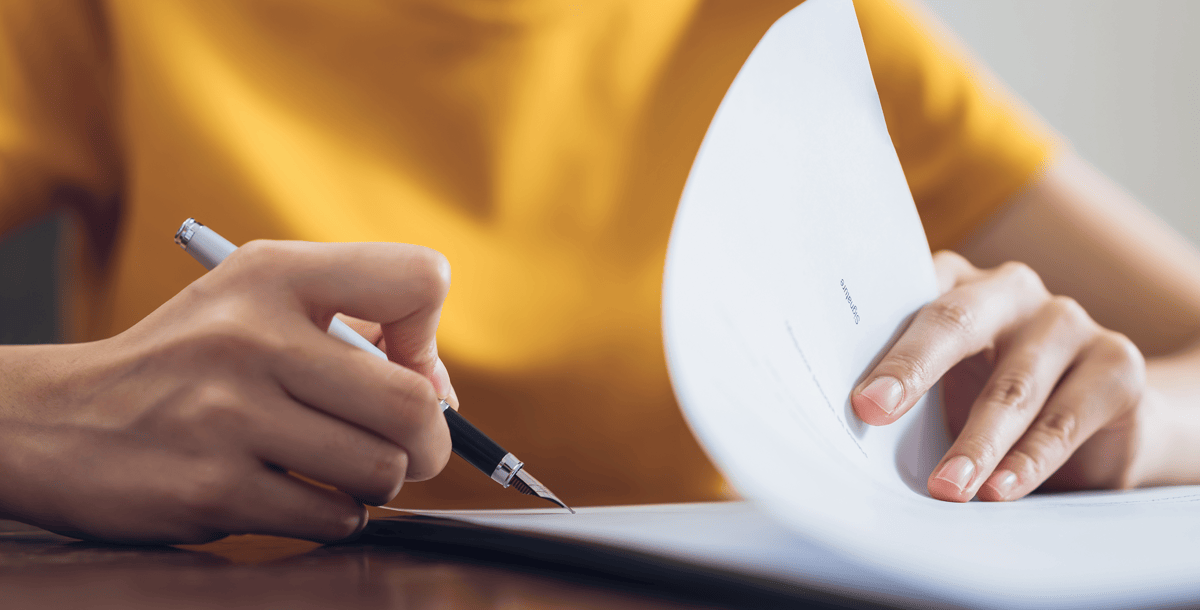 yellow shirt hand writing on paper