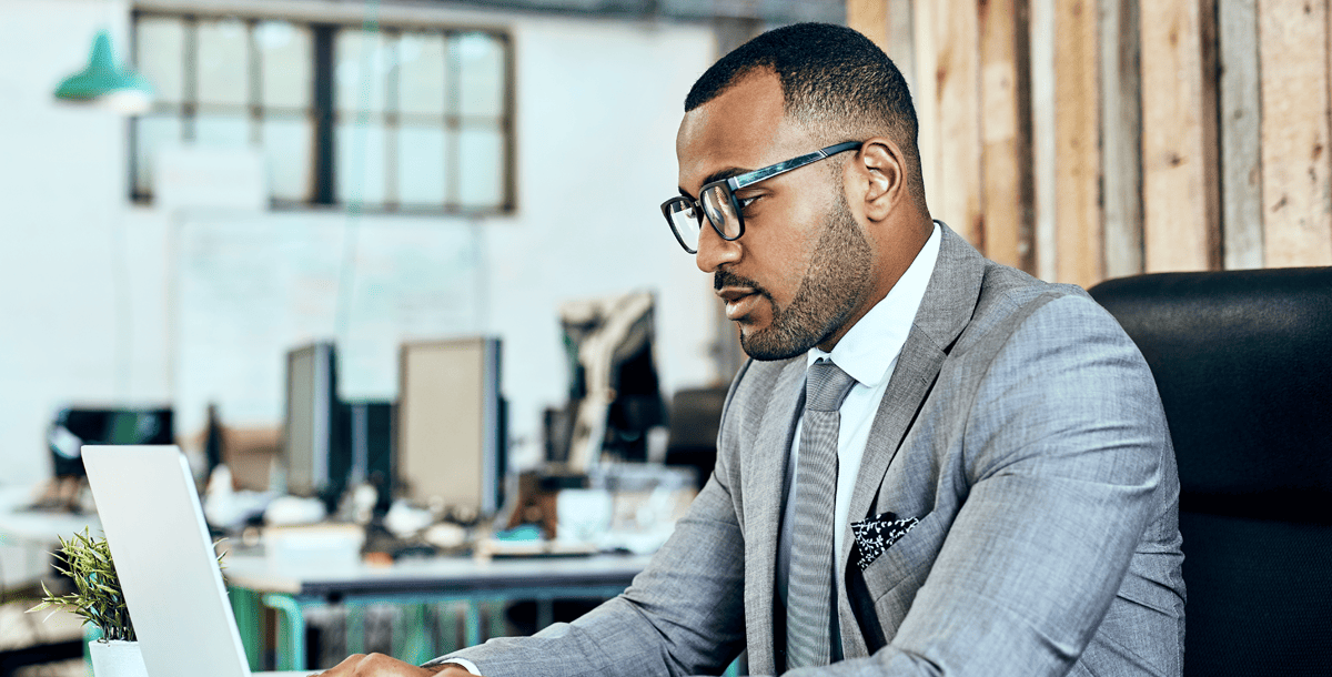 Man in suit looking at laptop