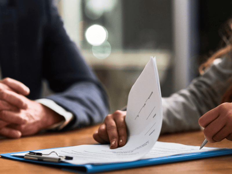 two people at desk signing paperwork