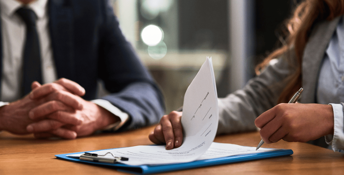 two people at desk signing paperwork