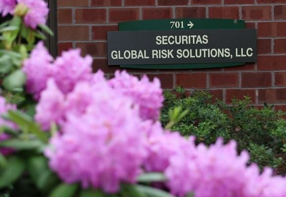 Photo of corporate office building sign stating 'Securitas Global Risk Solutions, LLC' with pink flowers